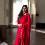Shop red Georgette saree with beads, stones and silver scalloped border. Comes with an unstitched blouse piece, perfect for festive and party wear.