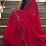Shop red Georgette saree with beads, stones and silver scalloped border. Comes with an unstitched blouse piece, perfect for festive and party wear.