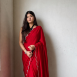 Shop red Georgette saree with beads, stones and silver scalloped border. Comes with an unstitched blouse piece, perfect for festive and party wear.