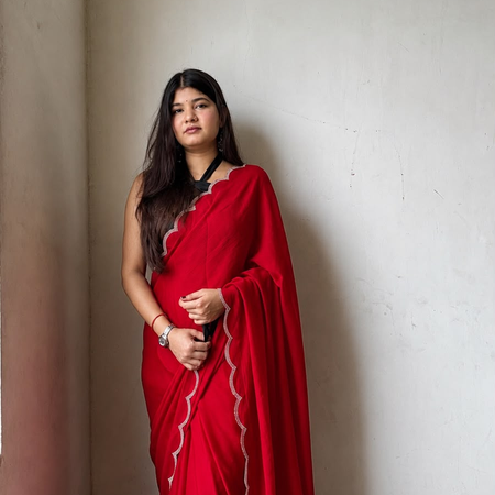 Shop red Georgette saree with beads, stones and silver scalloped border. Comes with an unstitched blouse piece, perfect for festive and party wear.
